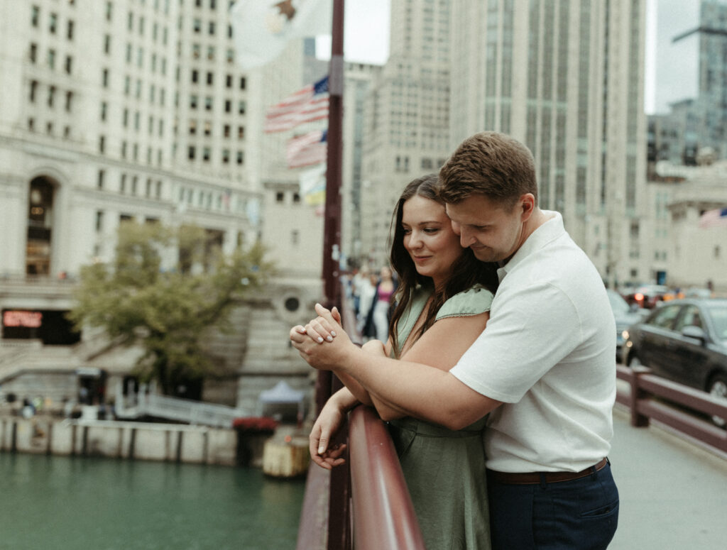 Couple holding hands while looking over a bridge in Chicago.