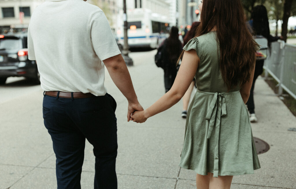 Couple walking in downtown Chicago while holding hands. 