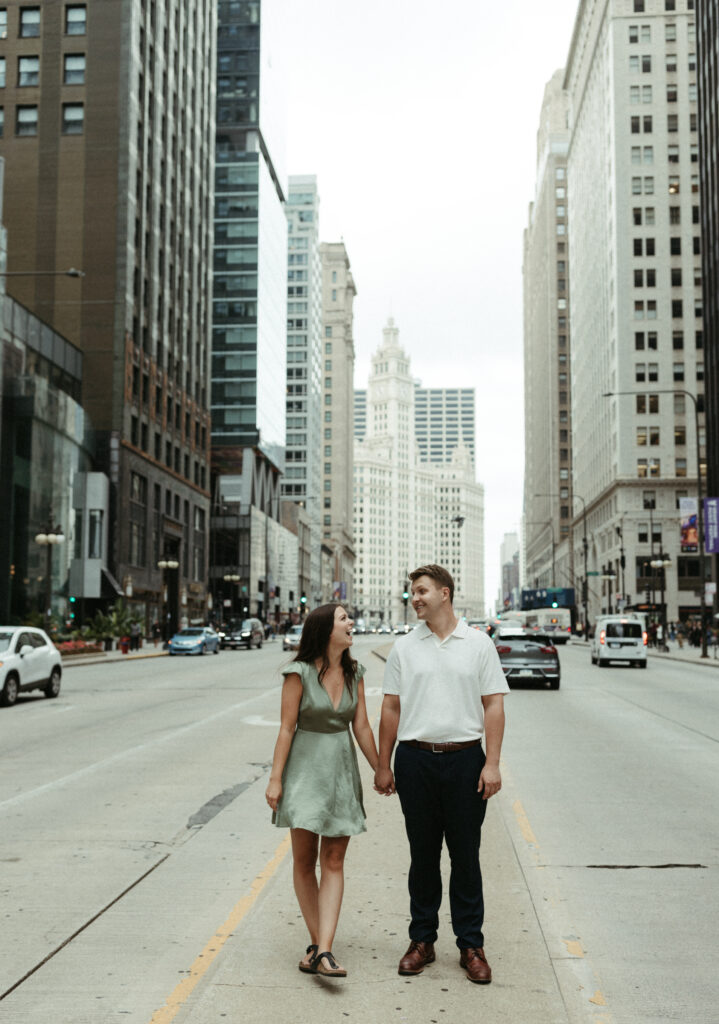 Woman wearing a green dress and man wearing a white shirt during their engagement session in Chicago. 