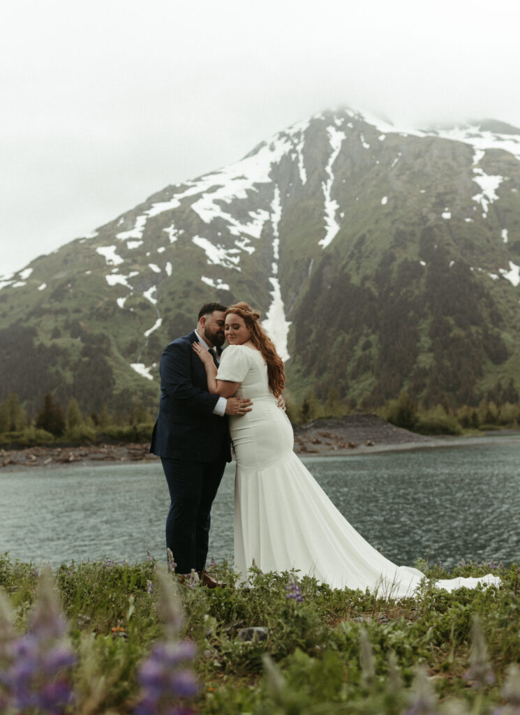 Couple standing next to the mountains during their day after session in Girdwood. 