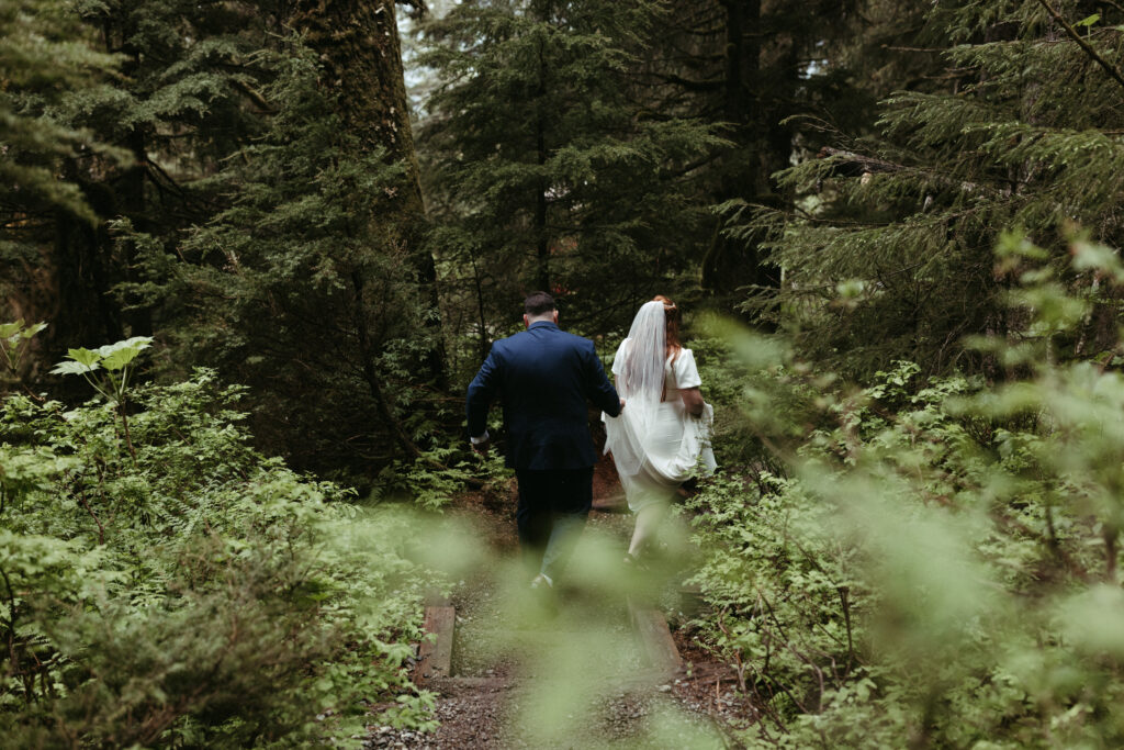 Couple walking in the woods during their day after session in Girdwood