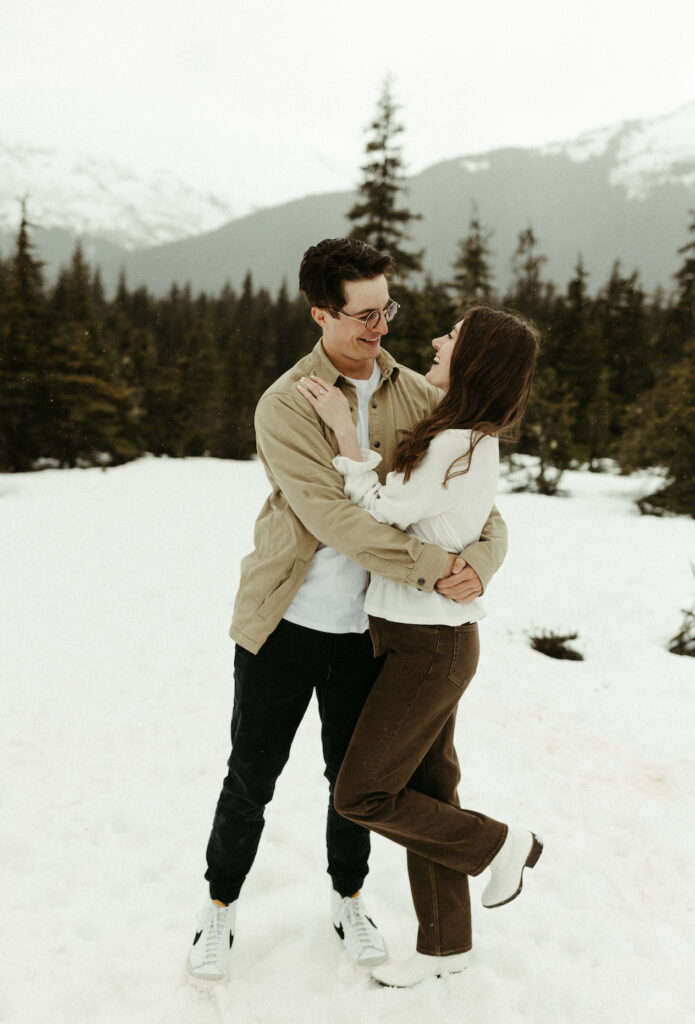 Couple holding onto one another in the snow