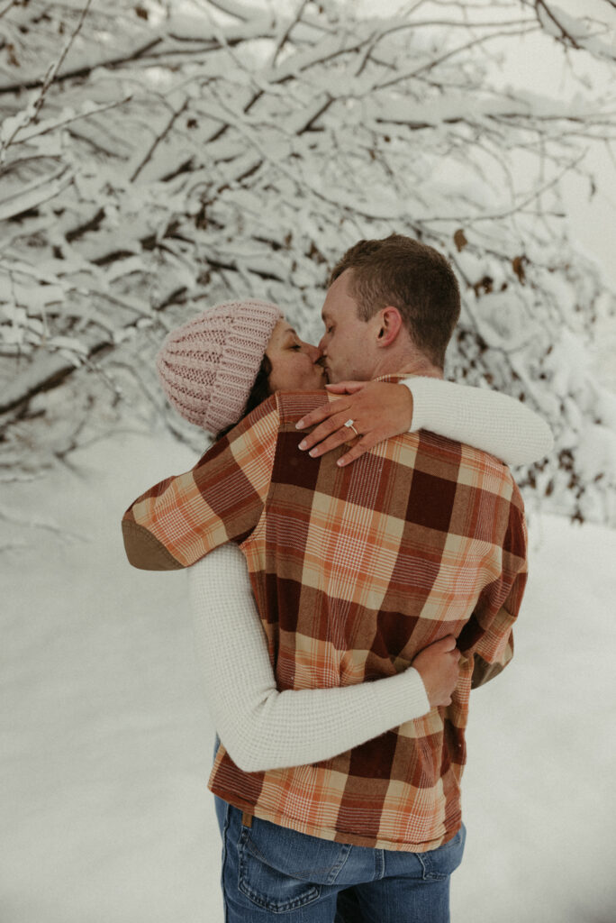 couple embracing one another while taking their engagement photos
