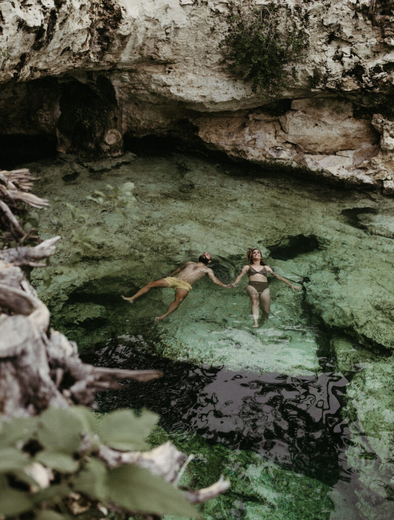 Couple swimming in a cenote after eloping. 