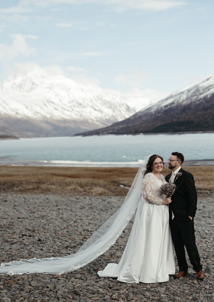 Couple standing next to the mountains during their Eklutna lake elopement.  