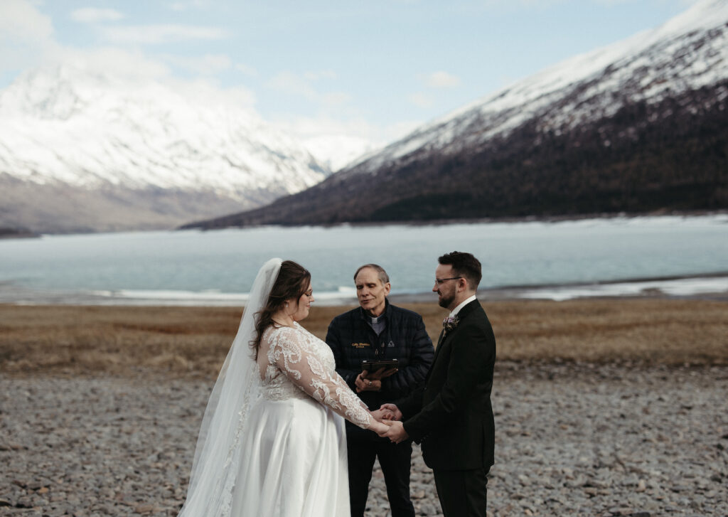 Couple holding hands during their Eklutna Lake elopement. 