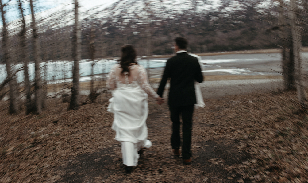 Couple walking through the woods while holding hands. 