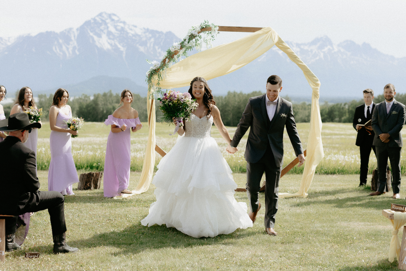 A couple walking away from a wood arch during a wedding in Wasilla, Alaska