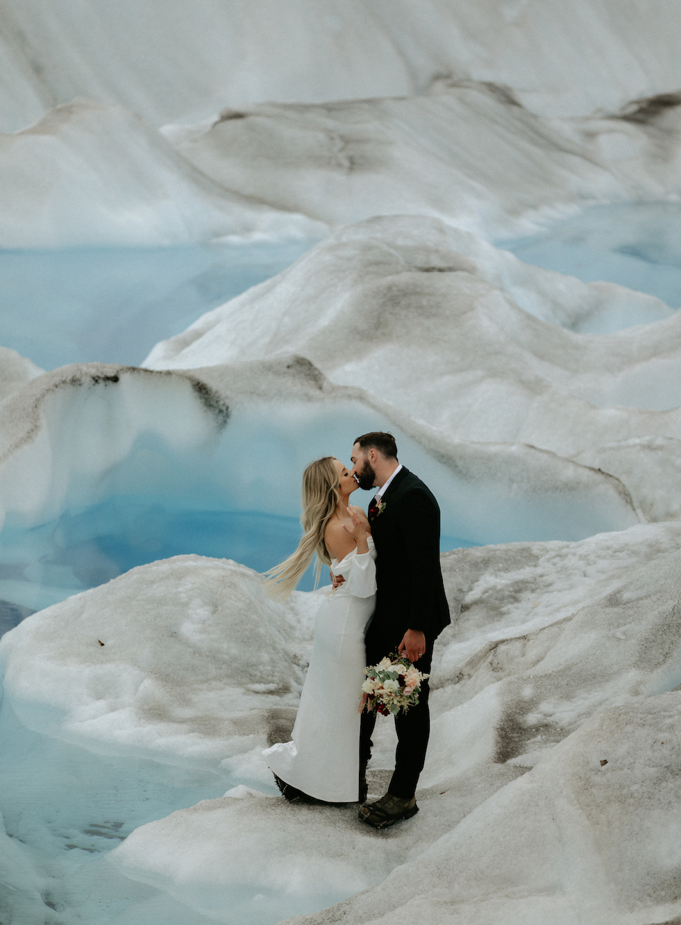 Couple kissing while on the Knik Glacier. A unique wedding location in Alaska. 