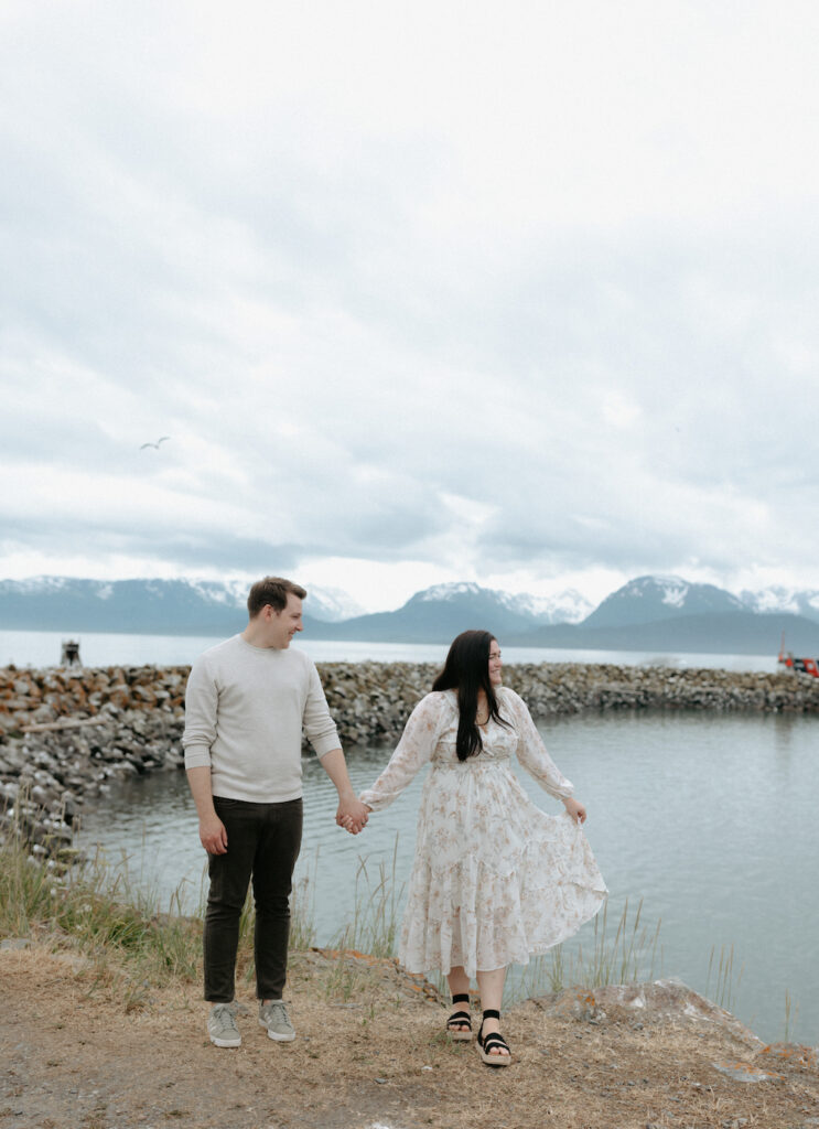 Man holding a womans hand while she sways in her dress