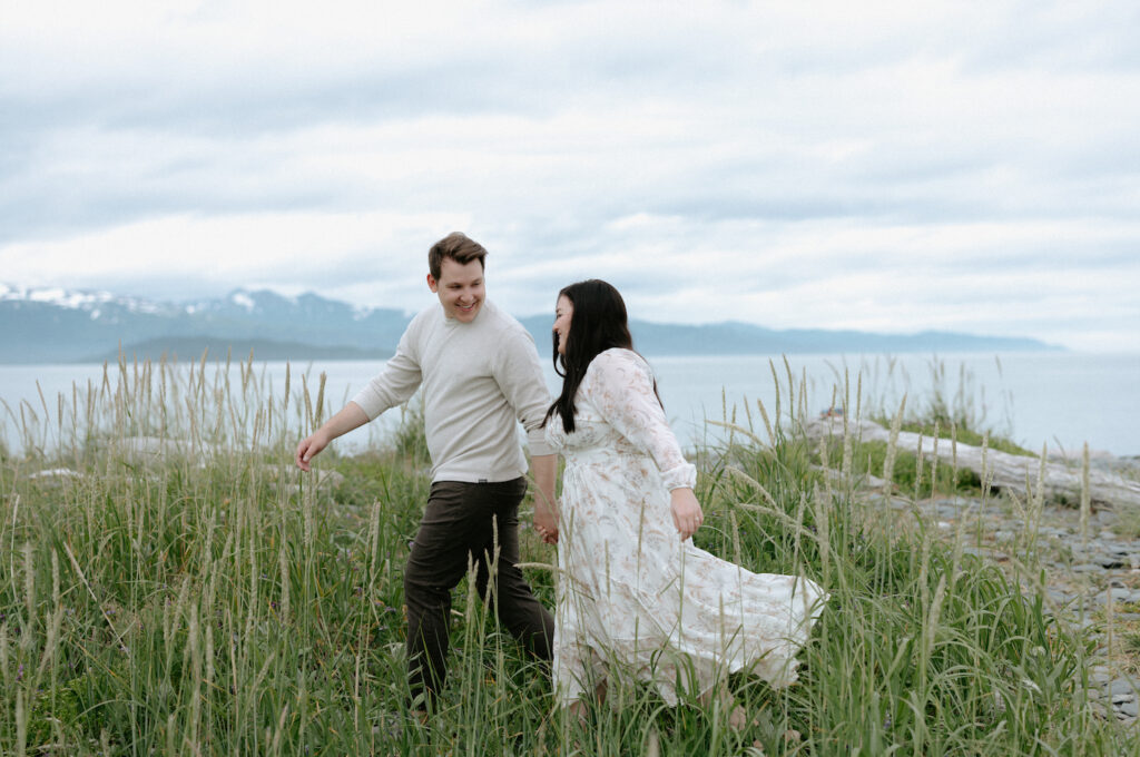 Man looking at woman while leading her through a field