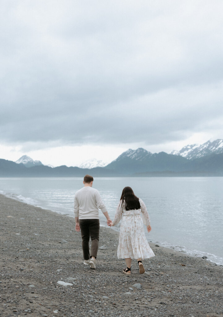 Couple walking toward the mountains while holding hands