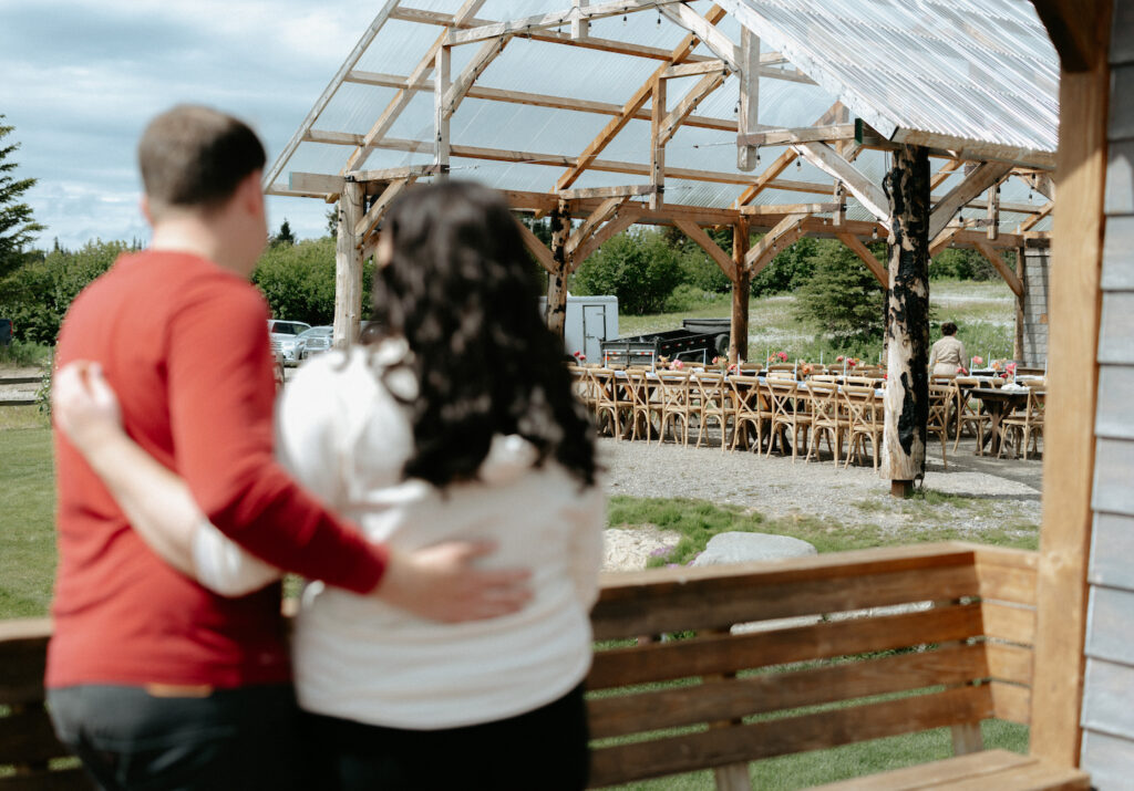 Couple watching as the florist pulls together their wedding reception space