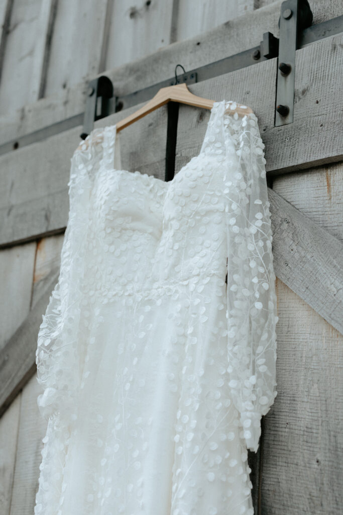 Wedding dress hanging up outside a barn venue in Alaska.