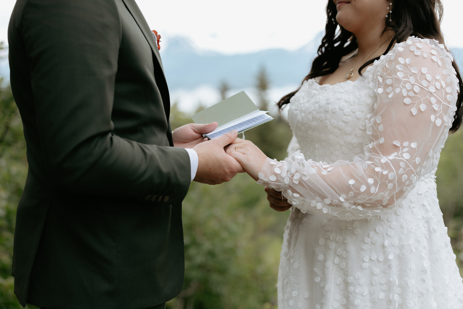 A couple holding hands and exchanging vows at Ak Diamond Ranch