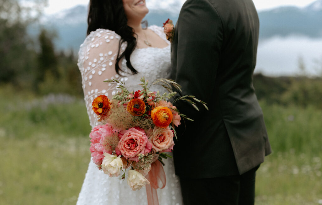 Pink flowers next to a white wedding dress.