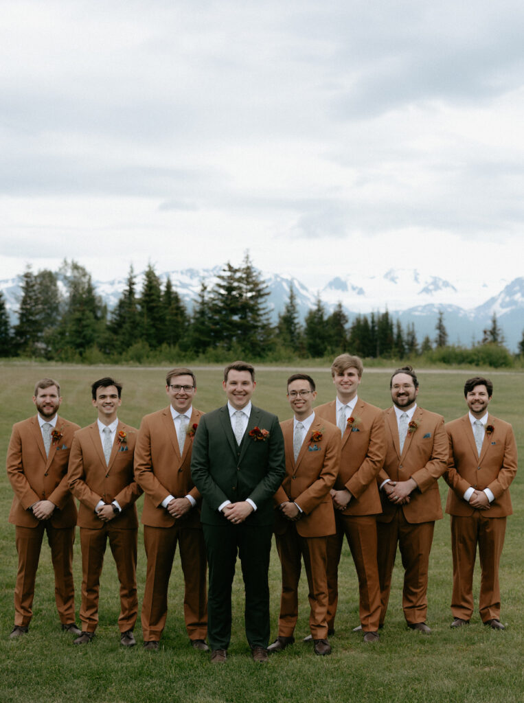 Man surrounded by other men while wearing wearing wedding attire