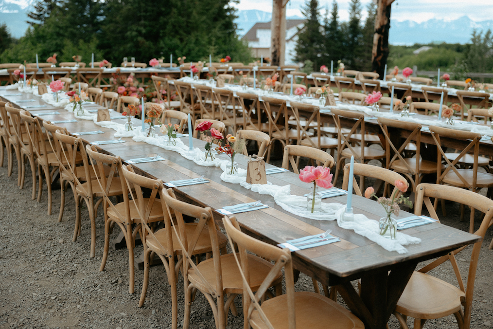 Flowers in vases lining a wooden table