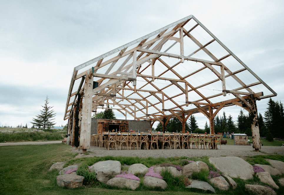 A pavilion set up with tables and chairs for a wedding reception. 