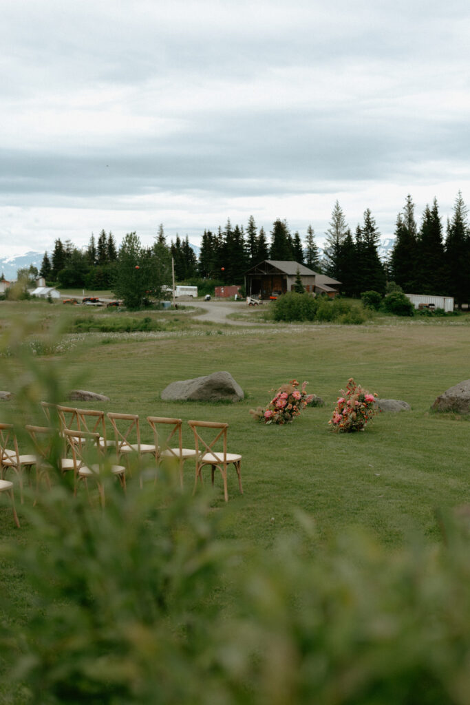 Florals and chairs set up on a piece of flat ground.