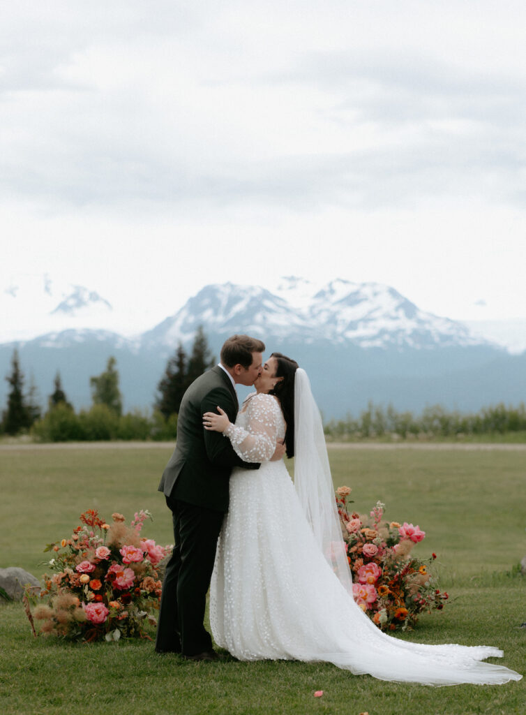 Man and woman kissing in front of the mountains