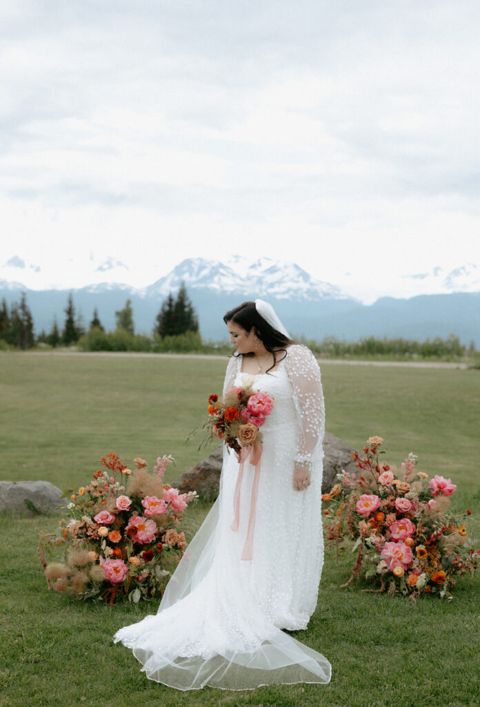 Bride standing in a wedding dress in front of the mountains