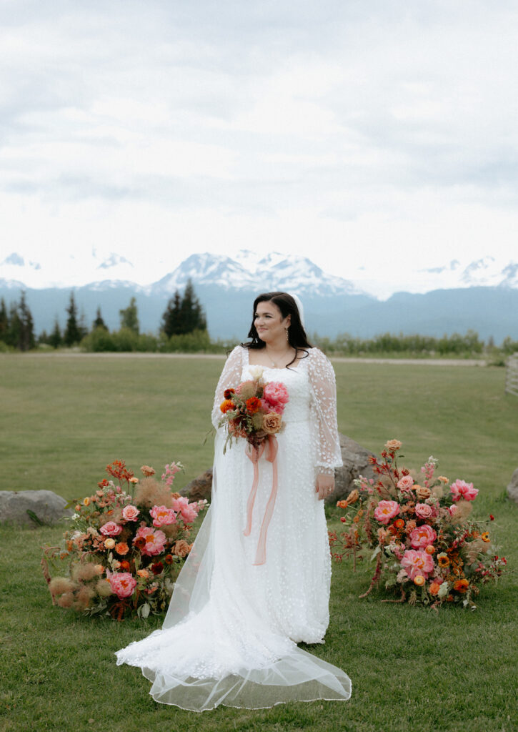 Bride looking away while standing in front of pink flowers.