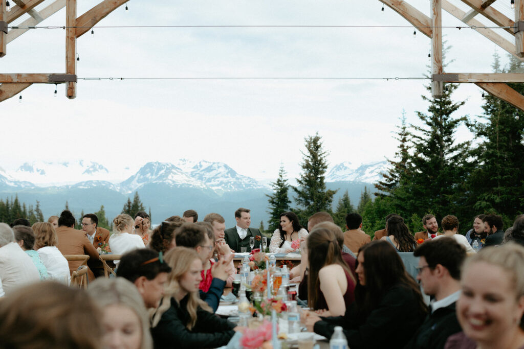 Couple sitting together surrounded by family and friends.