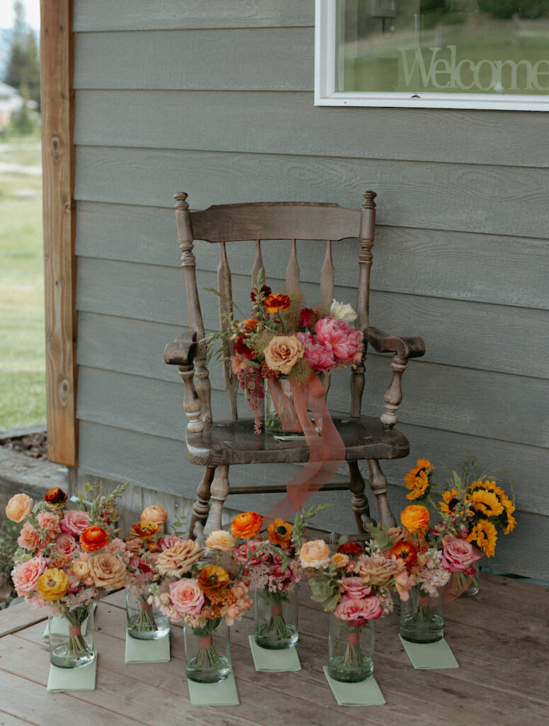 Wedding florals on a wooden chair outside a wedding venue in Alaska.