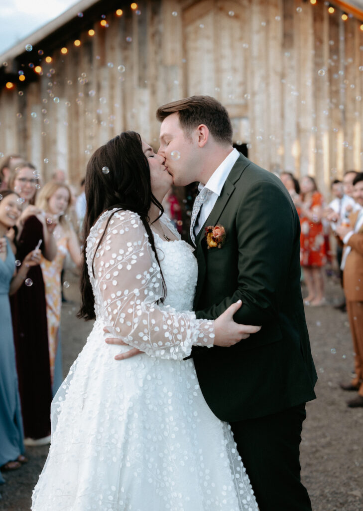 Couple kissing during a bubble exit outside their wedding venue in Homer, Alaska.