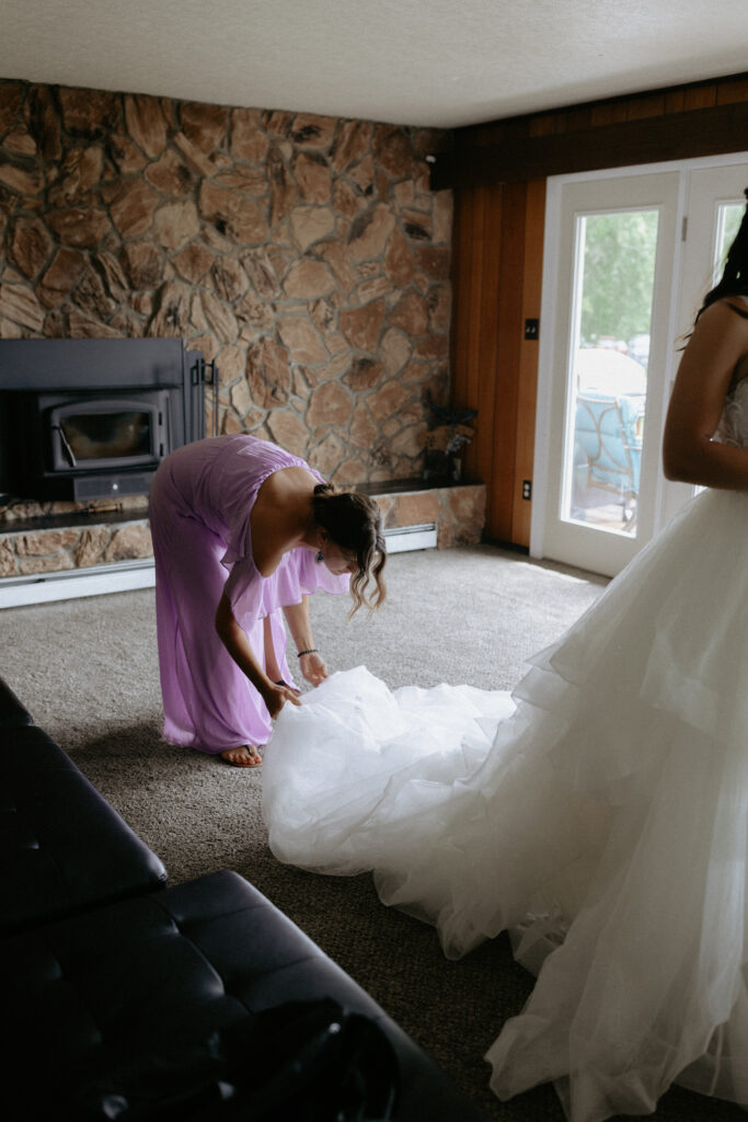 Woman laying out the train of a wedding dress.