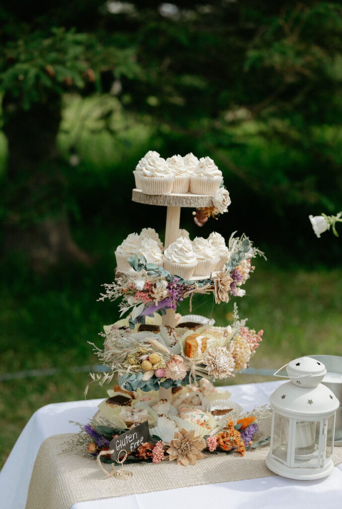 Cupcakes stacked on a wooden piece of wedding decor.