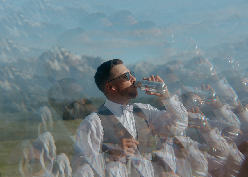 Groom drinking a beer during a wedding reception in Alaska. 