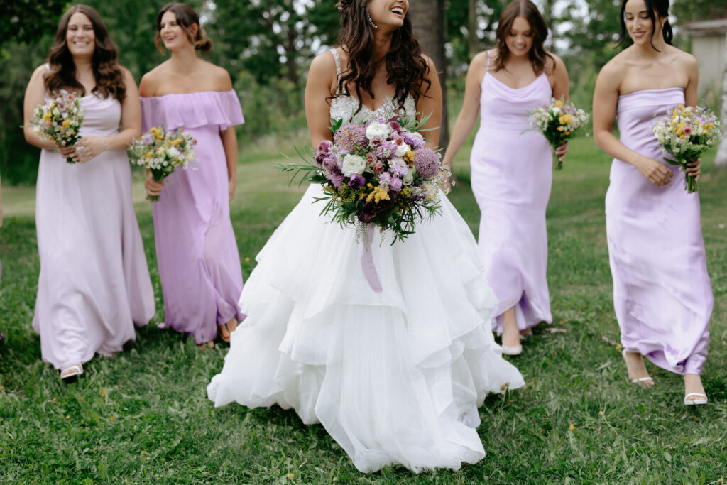 Woman holding flowers while surrounded by other woman.