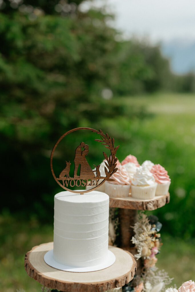 A white cake surrounded by cute wedding decor