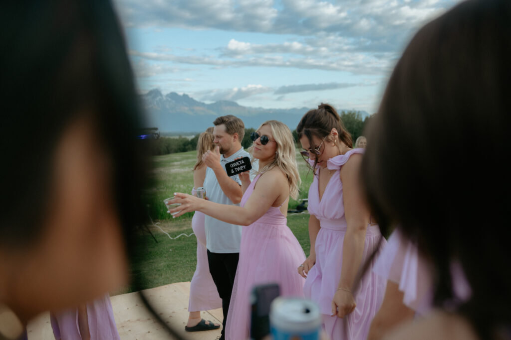 Woman holding a phone with the couples name on it. 