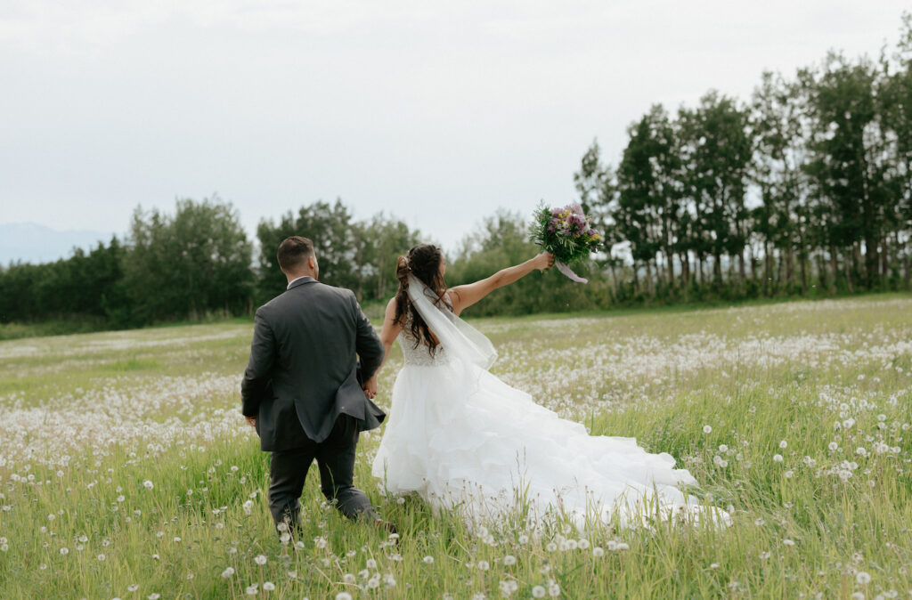 Couple running through a field of dandelions in Alaska. 