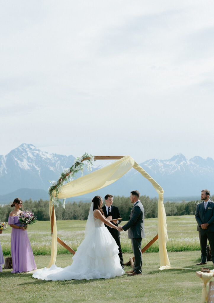 Couple holding hands while saying their wedding vows.