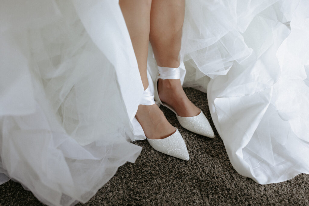 Woman wearing white shoes and a white dress on her wedding day