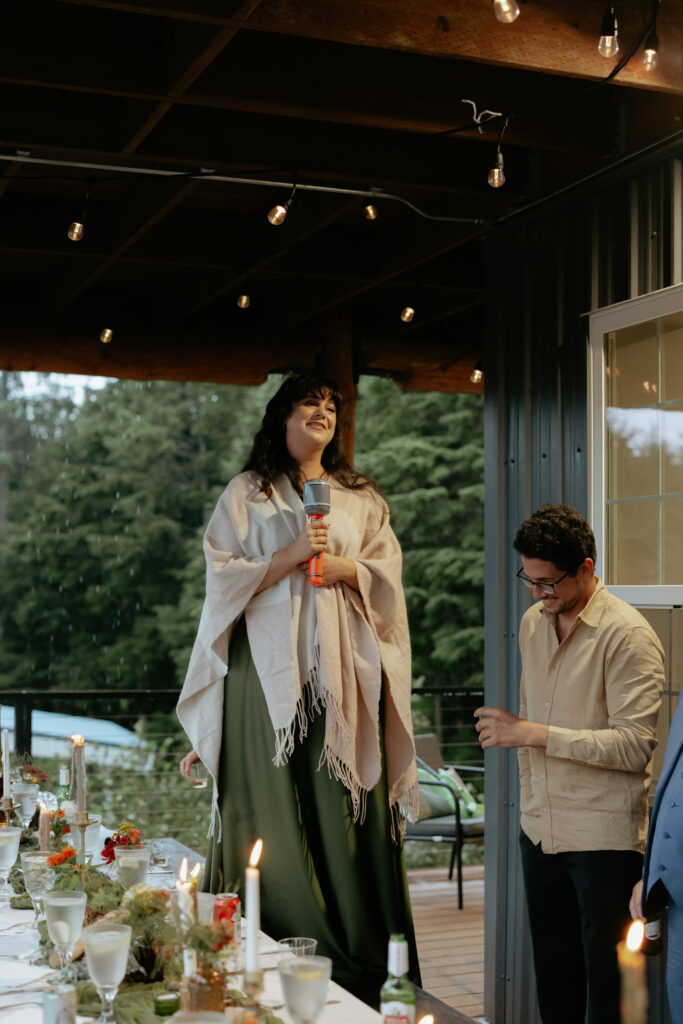 Woman standing on a chair and holding a microphone. 