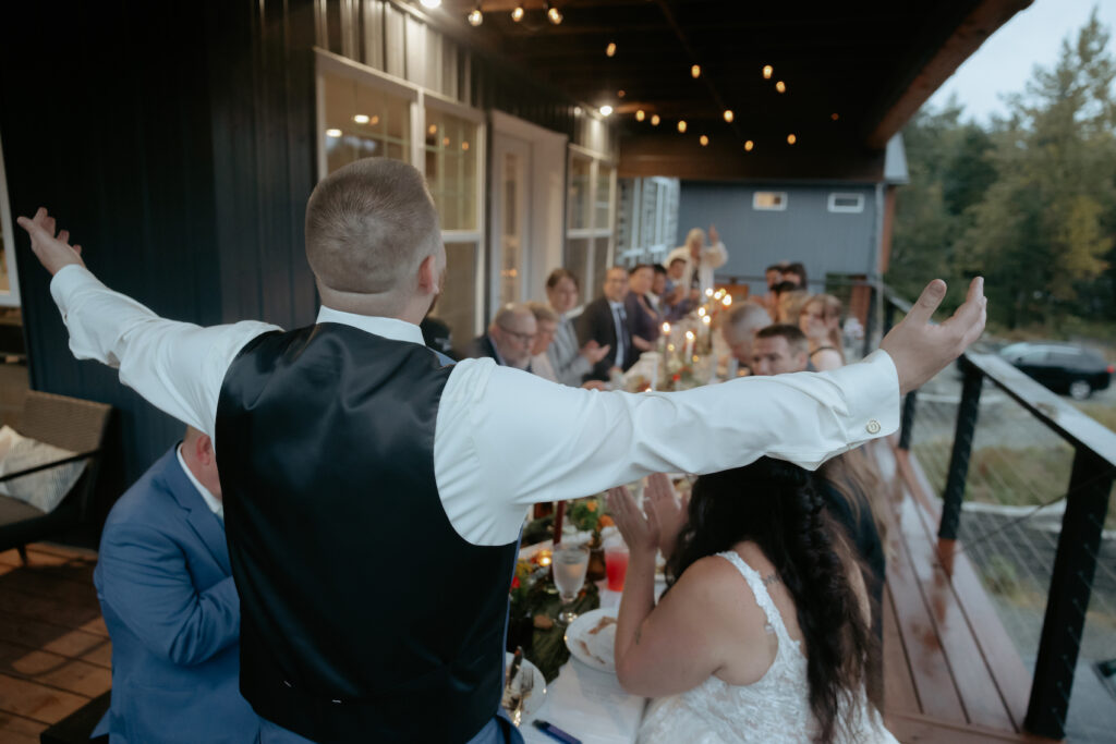 Man holding out arms at the head of the table