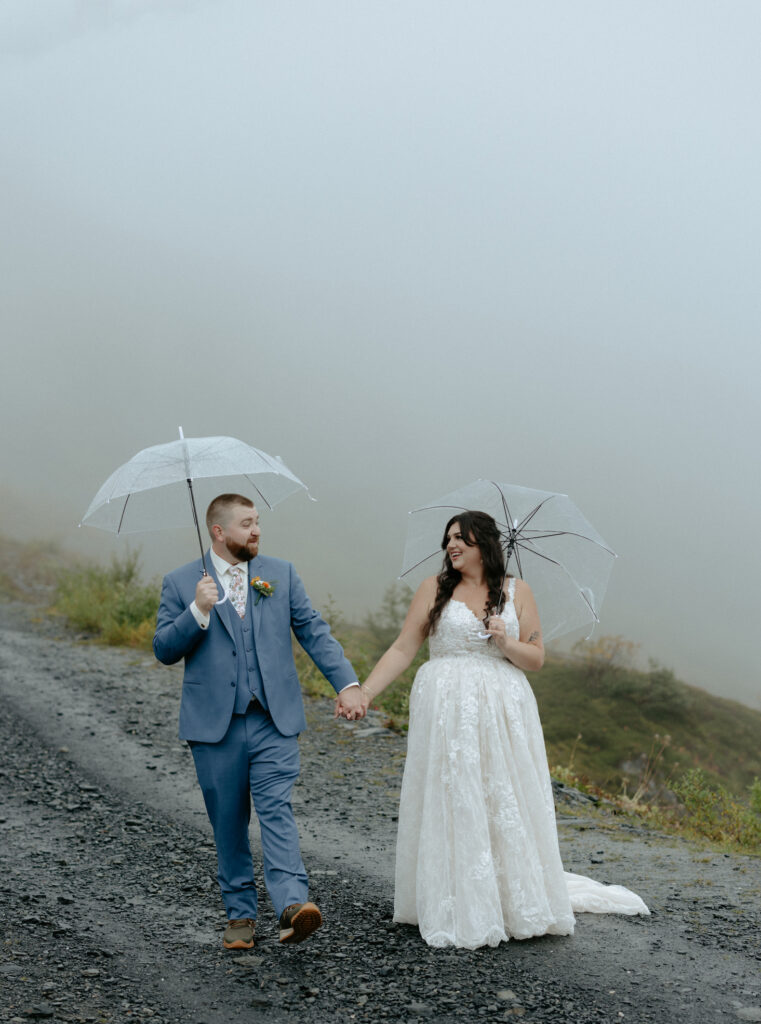 Man and woman walking while holding umbrellas