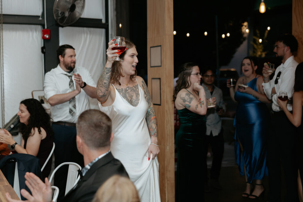 A woman holding up a glass during toasts. 