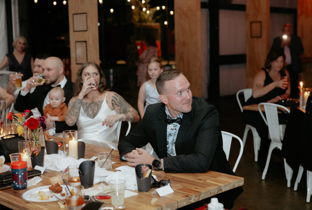 A group of people sitting at a table during toasts.