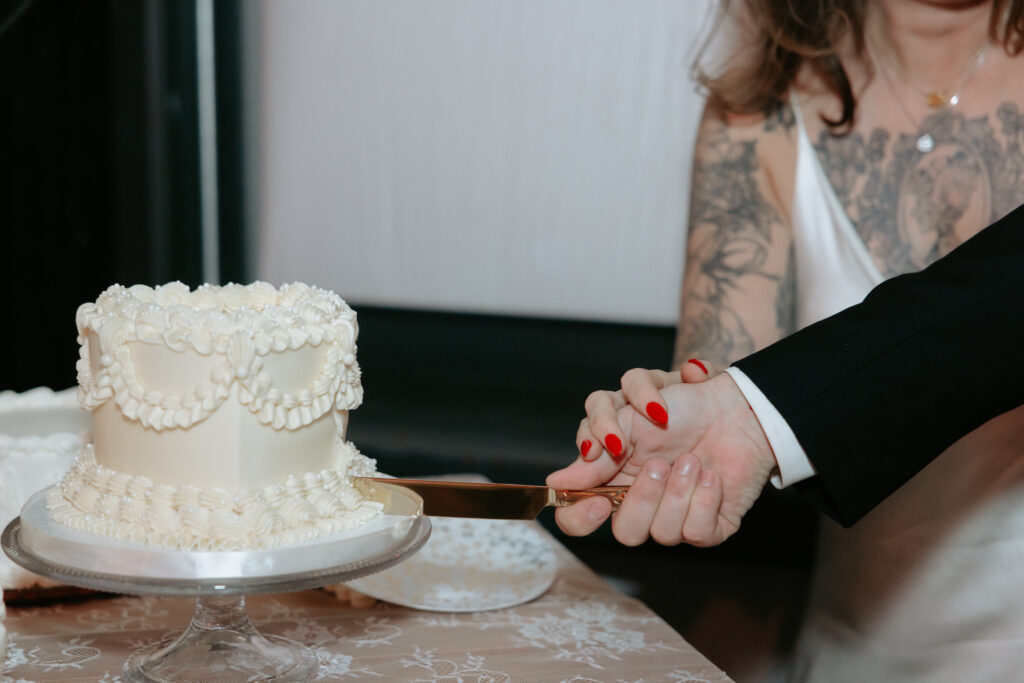 A couple cutting a cake together. 