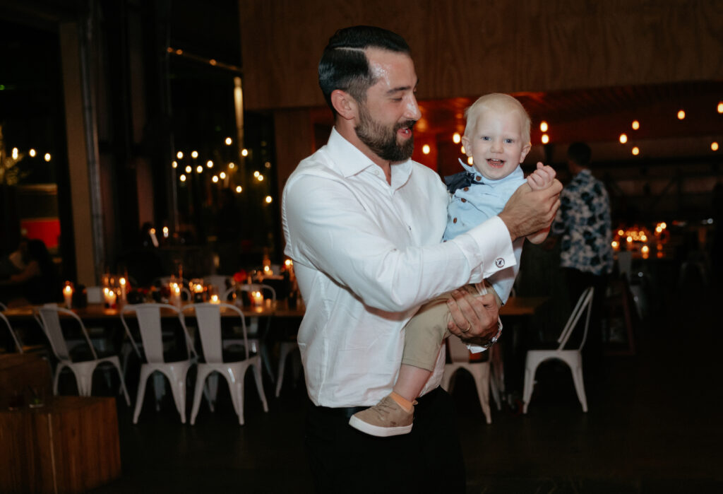 A baby being held while smiling. 