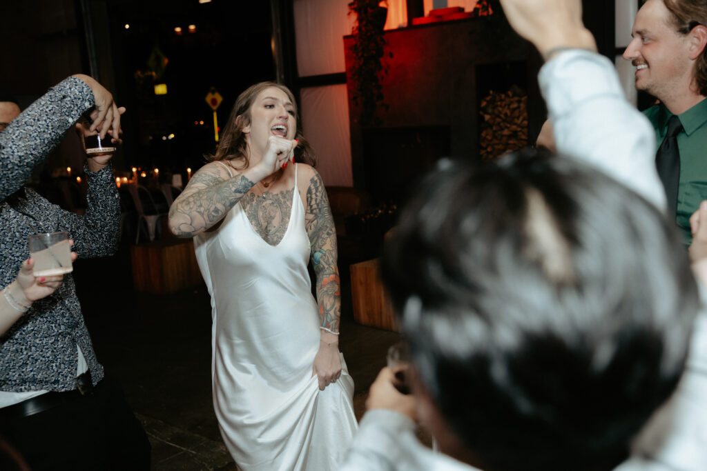 A woman dancing surrounded by a group of people. 