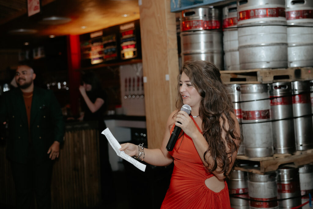 A woman holding a piece of paper and a microphone. 