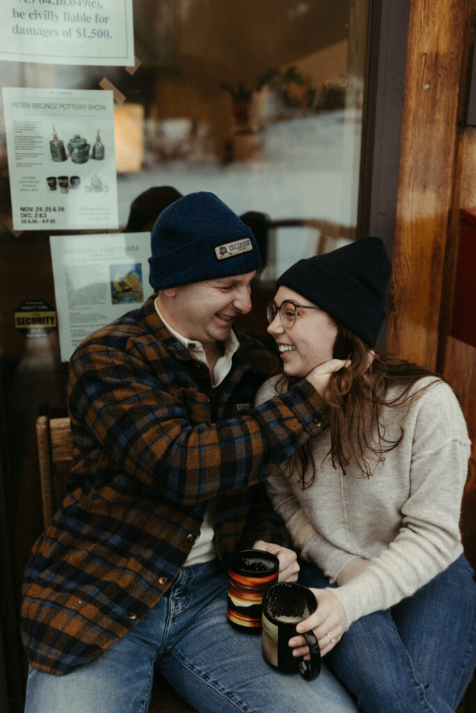 A man holding onto a woman's facer and both are laughing.