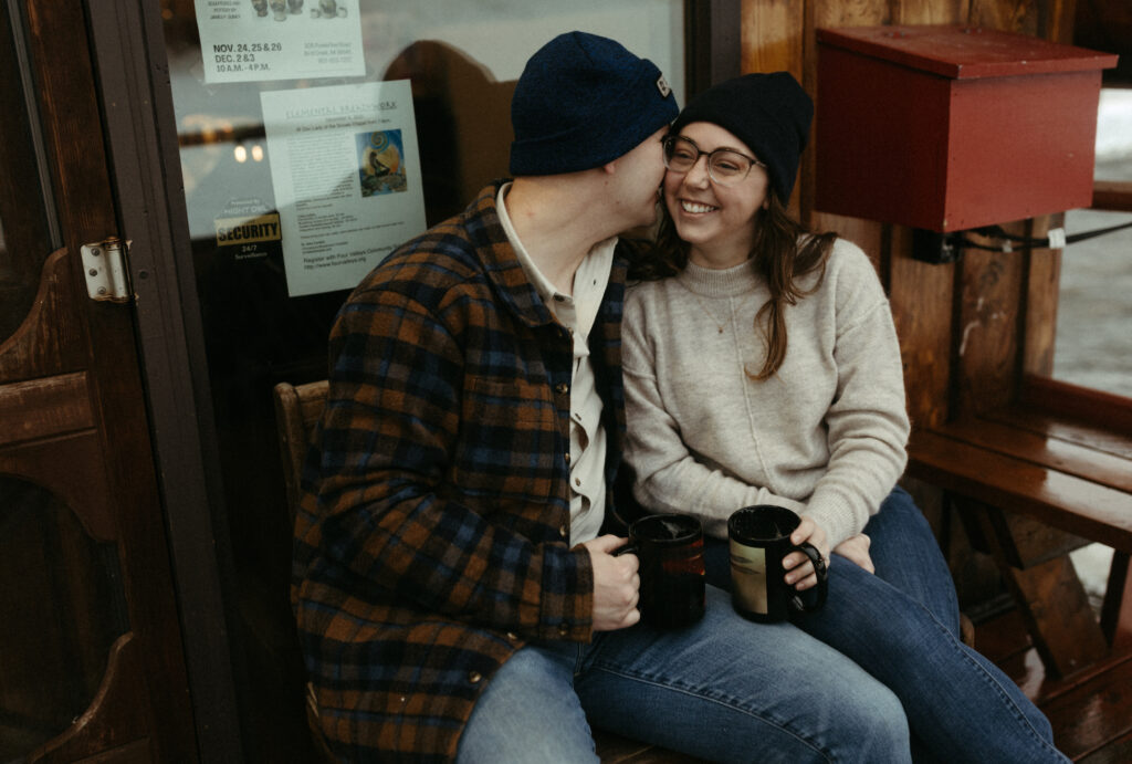 A man whispering in a woman's ear. 